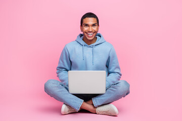 Photo of cheerful man blogger wear stylish clothes sitting floor use netbook macbook isolated on pink color background