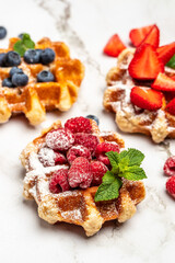 Traditional belgian waffles with fresh fruit on white background. vertical image. top view