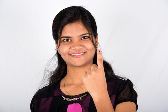 A indian young girl show her ink-marked fingers after casting vote in election.