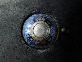 Safe or vault dial combination lock close up. Security, password authentication concept.  Black dial and gold plate. Shallow depth of field.