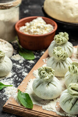 Khinkali with cheese and spinach. Raw semi-finished products dumplings. cooking khinkali. National Georgian cuisine. vertical image. top view