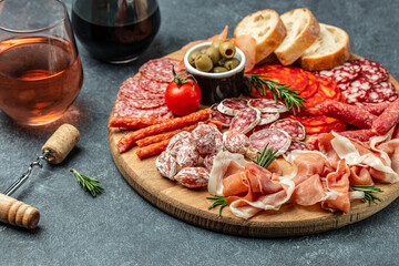 Salami, sliced ham, sausage, prosciutto, bacon. Meat antipasto platter wirh wine. Food recipe background. Close up