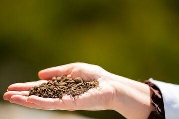 Female scientist holding a soil sample in her hand. Gmo plant research. Climate change research