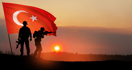 Fototapeta na wymiar Silhouettes of soldiers with Turkey flag on background of sunset. Concept of crisis of war and political conflicts between nations. Greeting card for Turkish Armed Forces Day, Victory Day.