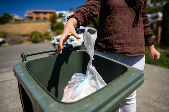 Throwing rubbish in the bin. Putting rubbish in an inside bin in australia