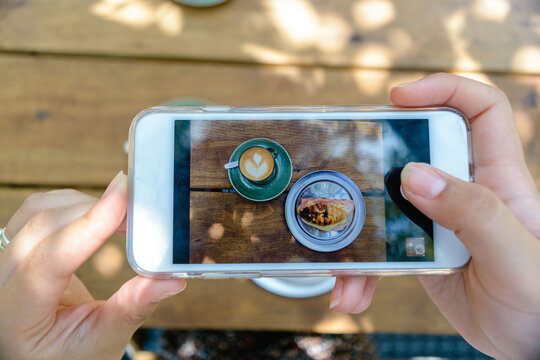 closeup of a phone screen with a picture of a croissant and a latte.