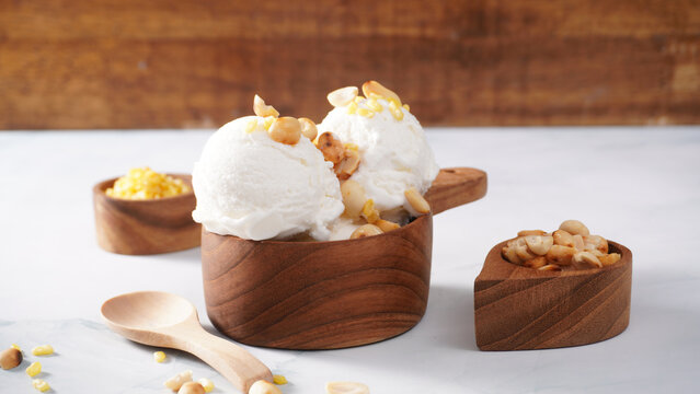 Coconut ice cream topped with roasted peanuts in a coconut shell