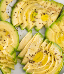 ripe avocado pulp cut into pieces sprinkled with lemon juice on a plate