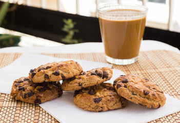 cookies with chocolate and hazelnuts and coffee with milk lie on the table