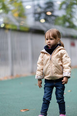 Little girl playing with swings at the playground