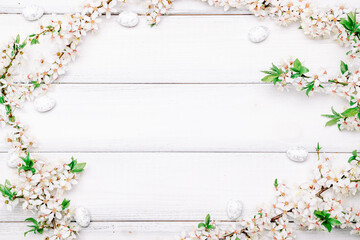 Easter eggs background. May flowers, white happy easter egg on wooden spring background. Easter card. Flat lay.