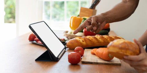 Happy couple preparing food together in kitchen at home ready to cook together