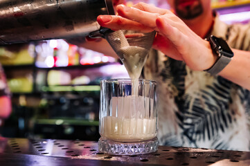 man hand bartender making white cocktail in glass on the bar counter