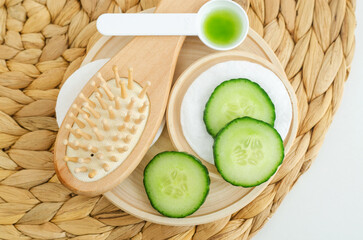 Cucumber slices and wooden hairbrush. Ingredients for preparing homemade face toner or beauty mask....