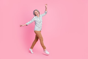 Full length photo of adorable dreamy woman dressed smart casual outfit walking dancing empty space isolated pink color background