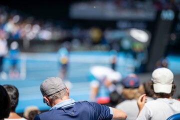 tennis fan watching a tennis match at the australian open eating food and drinking - obrazy, fototapety, plakaty