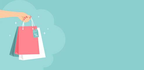 Female hand holding shopping bags on a green background with copy space. Vector illustration in flat style