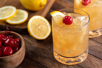 Whiskey sour cocktail with cherry and lemon