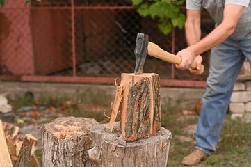 a man is chopping wood. alternative sources of heating.