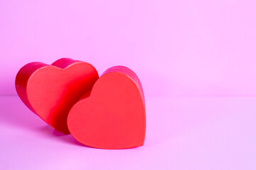 two red hearts in love on pink background