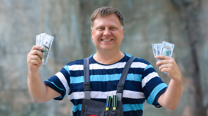 Happy blond worker with wages in his hands.