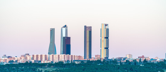 Fototapeta premium Madrid skyline with the towers of the financial area in the background and the moon rising at dusk 