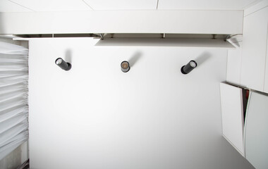 Modern ceiling interior in the kitchen. Black LED lights and white kitchen. Copy space for text