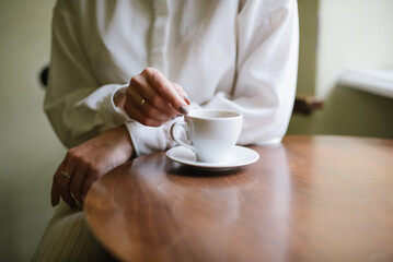 Close up photo of hands young girl and cup of coffee in the cafe indoor