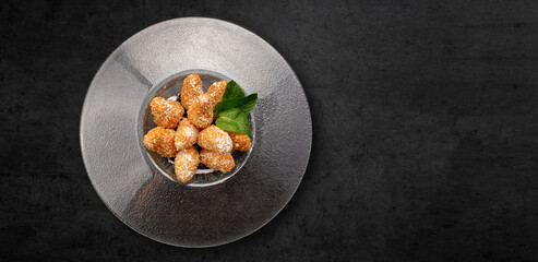 Cheese nuggets with mint and powdered sugar, in a plate