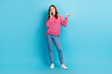 Obraz na płótnie Canvas Full length photo of young talking conversation lady wear pink sweater hold phone business tasks dialogue online isolated on blue color background