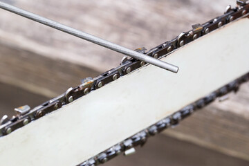 chainsaw chain sharpening with a special file. Dulling an old chain on a chainsaw bar. Industry