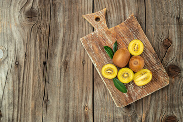 ripe yellow kiwi on a wooden board, banner, menu, recipe place for text, top view