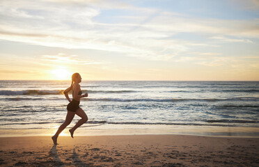 Fototapeta premium Woman, fitness and running on the beach in sunset for healthy cardio exercise, training or workout on mockup. Female runner exercising in sunrise for run, health and wellness by the ocean coast