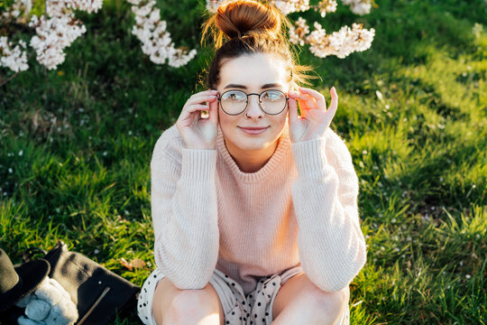 Portrait of young smiling caucasian hipster girl in glasses with pimples, acne on her face. Body positivity and diversity. Teenage skincare problems. Generation Z girl enjoy spring mood.