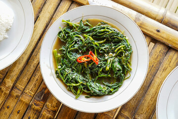 Stir-fried Water Spinach, Morning Glory, Stir-fried Kale, tumis kangkung served on a white plate