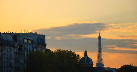 Fototapeta na wymiar Eiffel tower, dome of Academy of Fine Arts and typical Parisian buildings with attic at sunset. Paris, France.