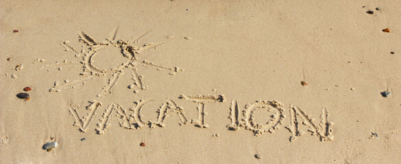 Word vacation and shape of sun written on sand at beach. Summer time
