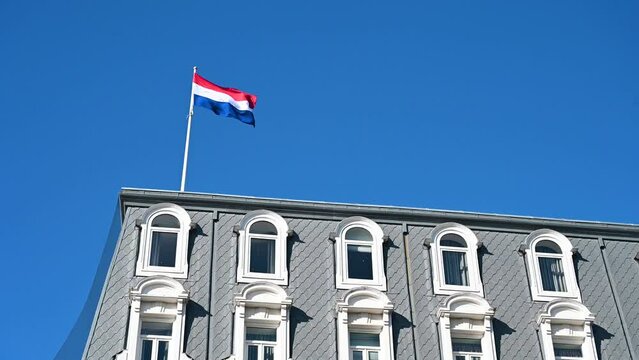 Flag of Netherlands in Amsterdam. The Dutch flag flies on the building. 