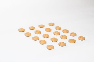 Grupo de medicamentos colocadas en fila una detrás de otra sobre un fondo blanco.