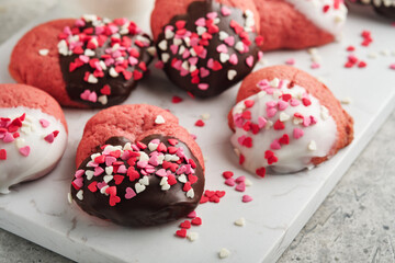 Valentines day cookies. Shortbread cookies with glaze white and dark chocolate and heart sprinkles on plate on white background. Mothers day. Womans day. Sweet holidays baking. Top view.