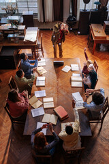 Goofy students throwing paper balls at professor.