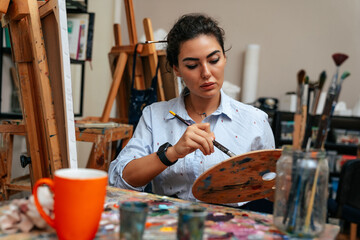 young artist working on a painting at the studio