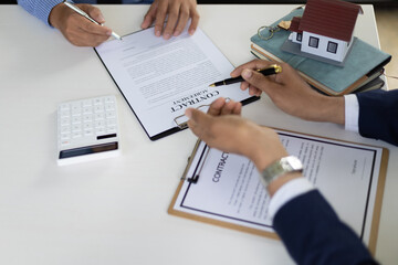 The real estate agent explaining the terms in the legal real estate agreement contract document, waiting for customer to sign. Mortgage, Lease, Home Insurance Concepts