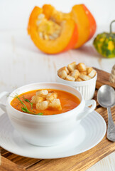 Pumpkin soup with croutons on white background.