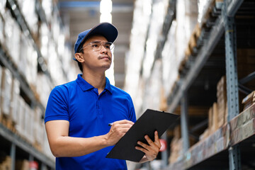 supply chain and logistic network technology concept. Happy Asian worker in blue uniform with...