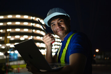 Asian engineer at power station using digital tablet working night shift at petroleum oil refinery in engineering industrial estate Fuel, renewable energy, industrial plants