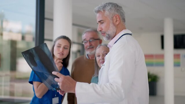 Doctor showing x-ray image to patients, explaining diagnosis.