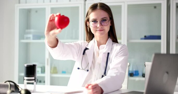 Doctor therapist holds red heart in cardiology clinic
