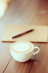 hot coffee in white cup on brown background