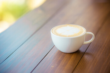 hot coffee in white cup on brown background